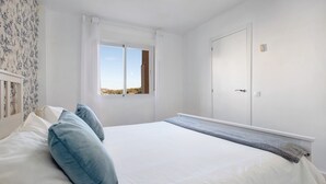 A bedroom with a bed, a window, a door, and a view of the landscape. - Apartment 'Armonia' with Sea View, Wi-Fi and Air Conditioning (Torremolinos)