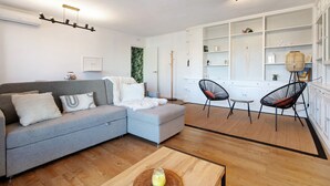 A living room with a grey sofa, a coffee table, and a dining area with chairs and a small table. - Apartment 'Armonia' with Sea View, Wi-Fi and Air Conditioning (Torremolinos)
