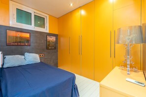 Une chambre à coucher avec un lit, une table de chevet, une lampe et deux tableaux encadrés accrochés au mur.