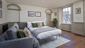 Une chambre à coucher avec un lit, un canapé, une fenêtre et un radiateur.