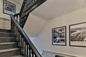A staircase with a handrail and a wall with two framed black and white photographs.