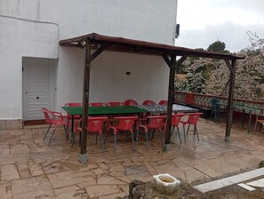 An outdoor patio with a table and chairs, a pergola, and a white building in the background. - Holiday Home 'Casa Calafell' with Mountain View, Wi-Fi and Air Conditioning (SEGUR DE CALAFELL)