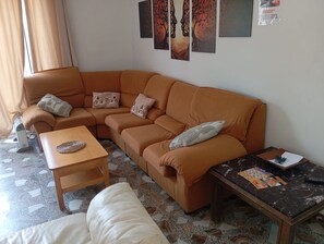 A living room with a brown sofa, a wooden coffee table, a white couch, and a marble table with magazines and pens. - Holiday Home 'Casa Calafell' with Mountain View, Wi-Fi and Air Conditioning (SEGUR DE CALAFELL)