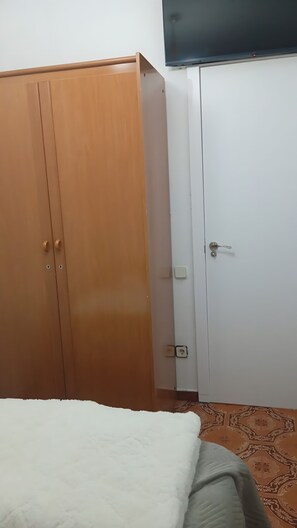 A room with a wardrobe, a bed, and a television. - Holiday Home 'Calafell' with Mountain View, Wi-Fi and Air Conditioning (SEGUR DE CALAFELL)