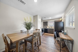 Enjoy meals in this kitchen with a central island, microwave and oven, and dining area with a wooden table and four chairs.