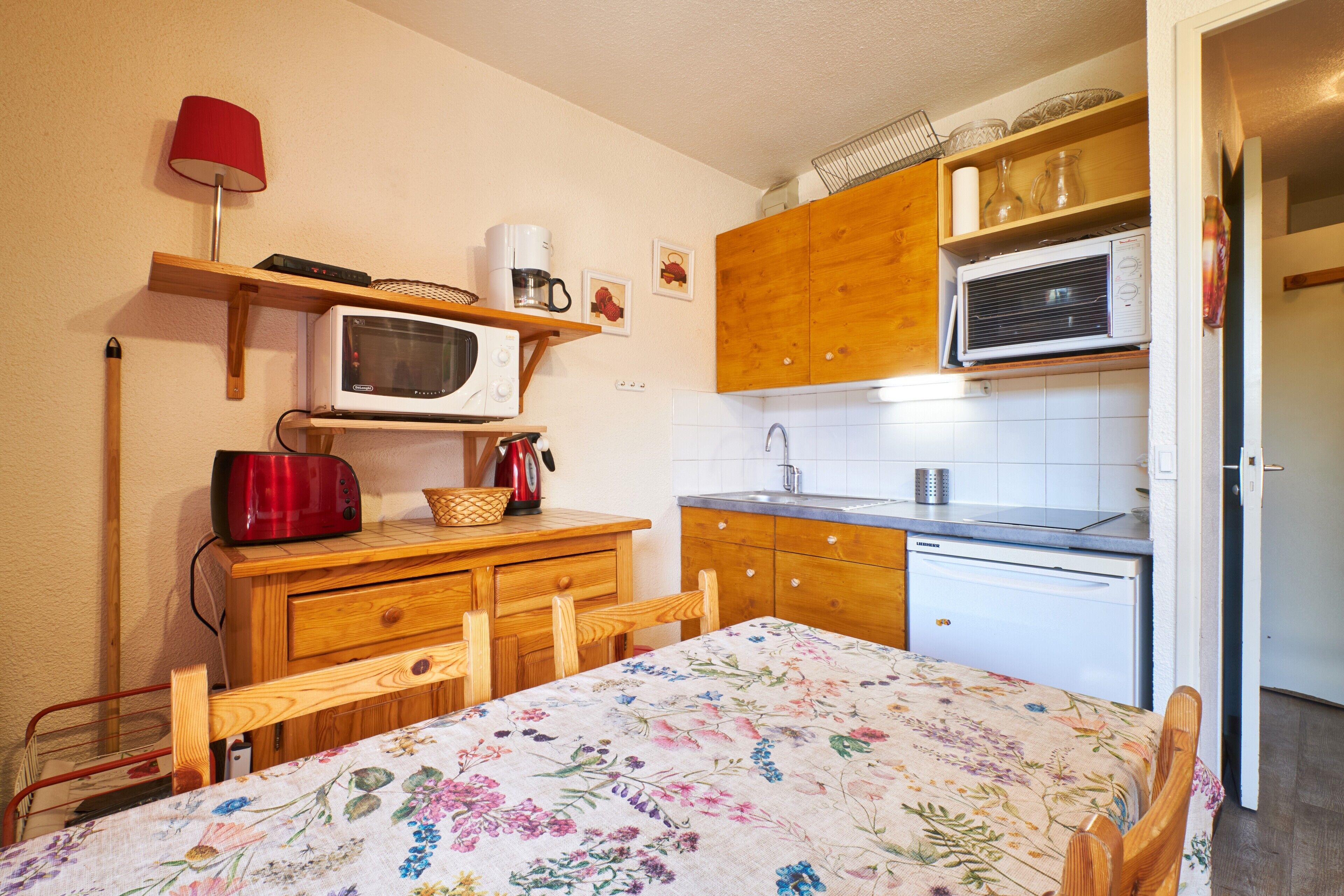 A compact kitchen with a microwave, toaster, and sink.