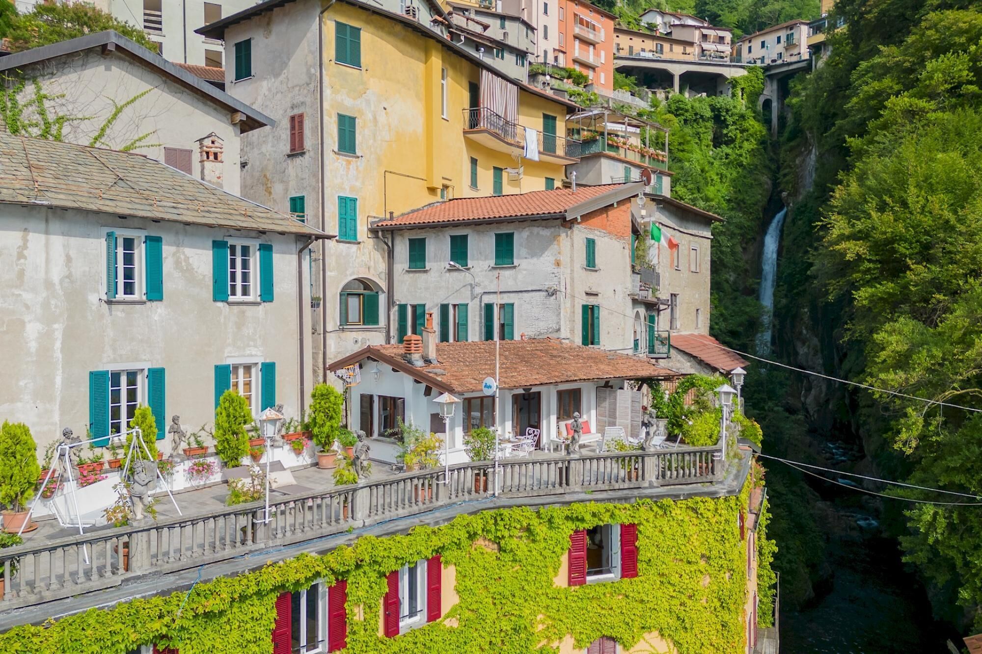 A multi-story building with balconies and a view of a waterfall.