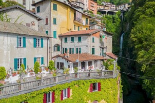 A multi-story building with balconies and a view of a waterfall.