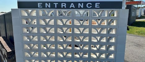 A sign for Surf Beach Motel with an entrance gate.