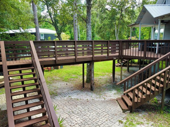 Una terraza de madera con una escalera que lleva a un área cubierta.