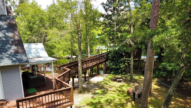 A deck with outdoor seating and a covered area, surrounded by trees and a wooden deck.