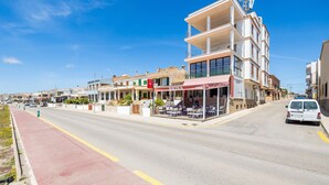 A street with buildings, a red bike lane, and a white van. - Apartment 'Brisas Vista Mar' with Sea View, Wi-Fi and Air Conditioning (Sa Ràpita)