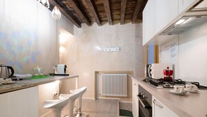 A modern kitchen with a bar area, a built-in stove, and a radiator. - Vacation Home "Ca' Lirica" with Wi-Fi & A/C (Venezia)