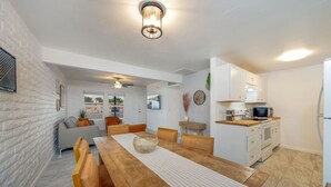 A modern kitchen with white cabinets, a microwave, and a refrigerator. - Central / Remodeled / Fenced / Clean / 3 BR 2 BA (Tucson)