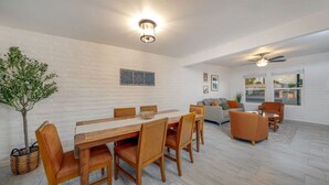 A spacious living area with a dining table, chairs, a sofa, and a ceiling fan. - Central / Remodeled / Fenced / Clean / 3 BR 2 BA (Tucson)