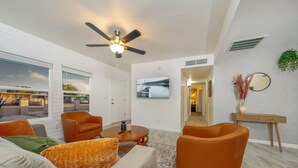 A modern living room with a ceiling fan, a coffee table, and orange armchairs. - Central / Remodeled / Fenced / Clean / 3 BR 2 BA (Tucson)