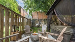 An outdoor deck with Adirondack chairs, a fire pit, and a hot tub. - ★ HostWise Stays ★ Luxe Hot Tub | Great Patio | Driveway Parking (Pittsburgh)