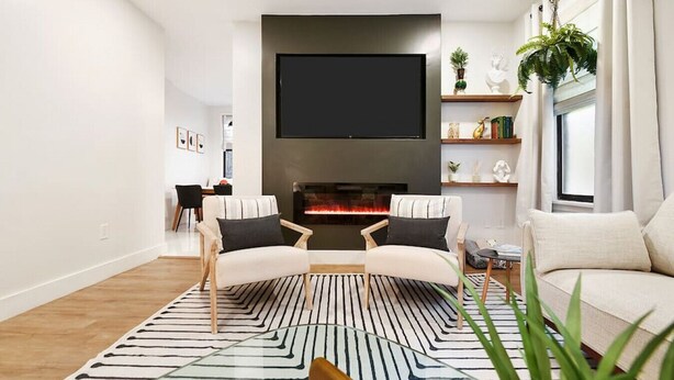 A modern living room with a fireplace, two armchairs, a sofa, a TV, and a bookshelf. - ★ HostWise Stays ★ Luxe Hot Tub | Great Patio | Driveway Parking (Pittsburgh)
