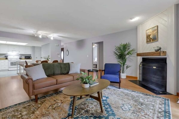 A living room with a sofa, coffee table, and fireplace.