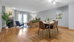 Un salon moderne avec une cheminée, une table à manger et des chaises.