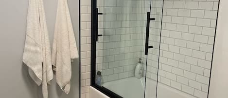 Een bad, een haardroger, handdoeken, shampoo