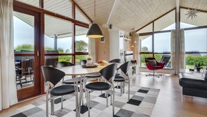 A spacious dining area with a large table and chairs, a checkered rug, and a view of the outdoors. - "Juliana" - 400m from the sea by Interhome (Nordborg)