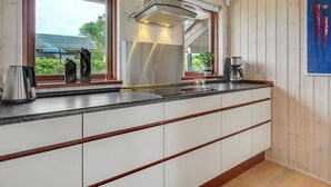A modern kitchen with a large island, stainless steel appliances, and wooden cabinetry. - "Juliana" - 400m from the sea by Interhome (Nordborg)