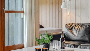 A modern living room with a white table, leather sofa, and a potted plant. - "Juliana" - 400m from the sea by Interhome (Nordborg)