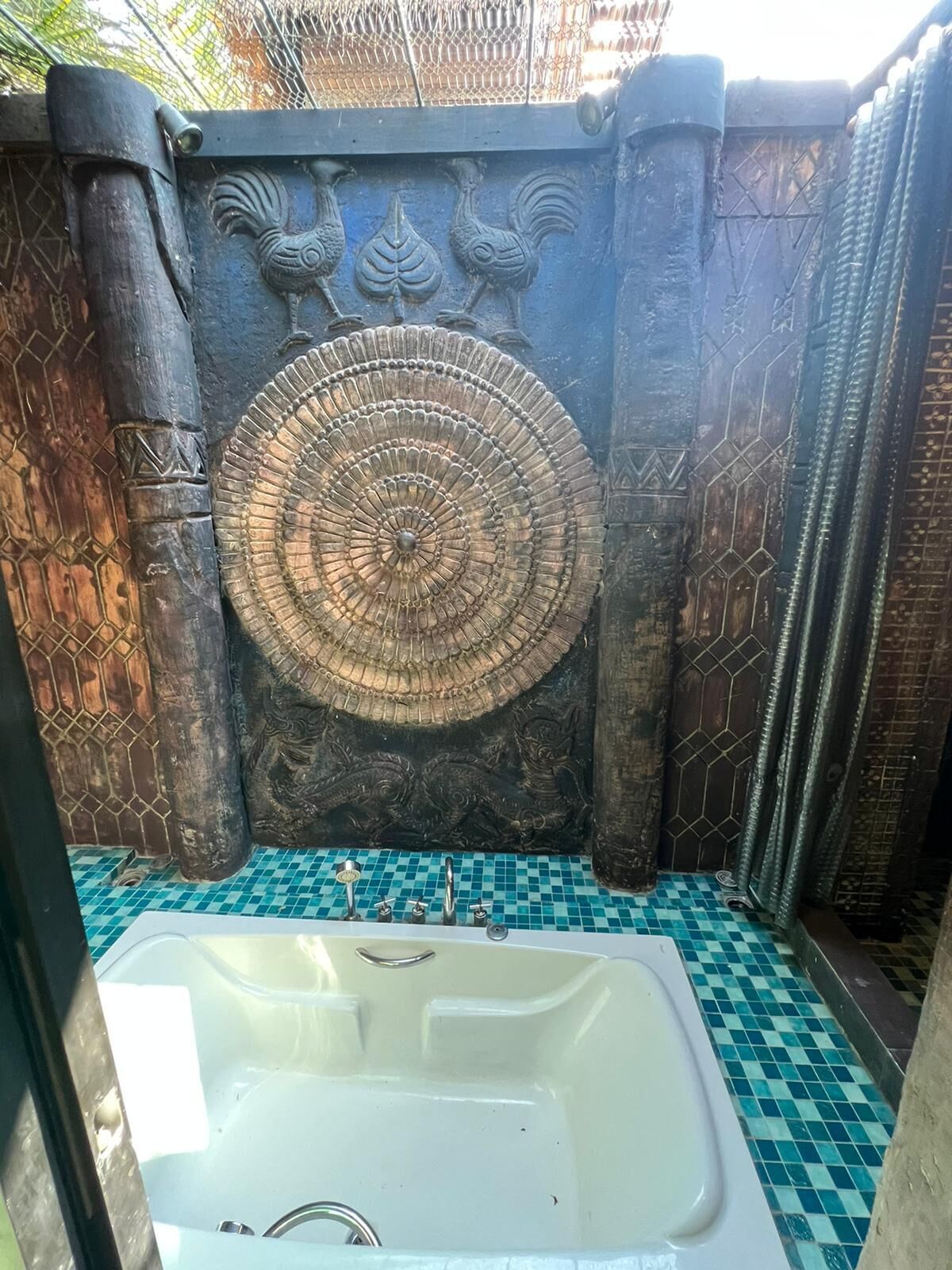 A spa area with a large circular stone wall, a bathtub, and a checkered floor.
