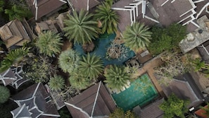 An aerial view of a courtyard with palm trees, a swimming pool, and a small bridge. - K2 Xanadu Pool Villa (Bang Lamung)