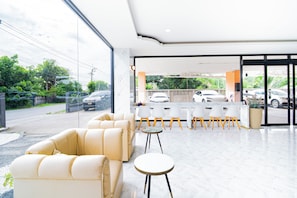 Una zona de recepción moderna con un sofá, sillas y mostrador.