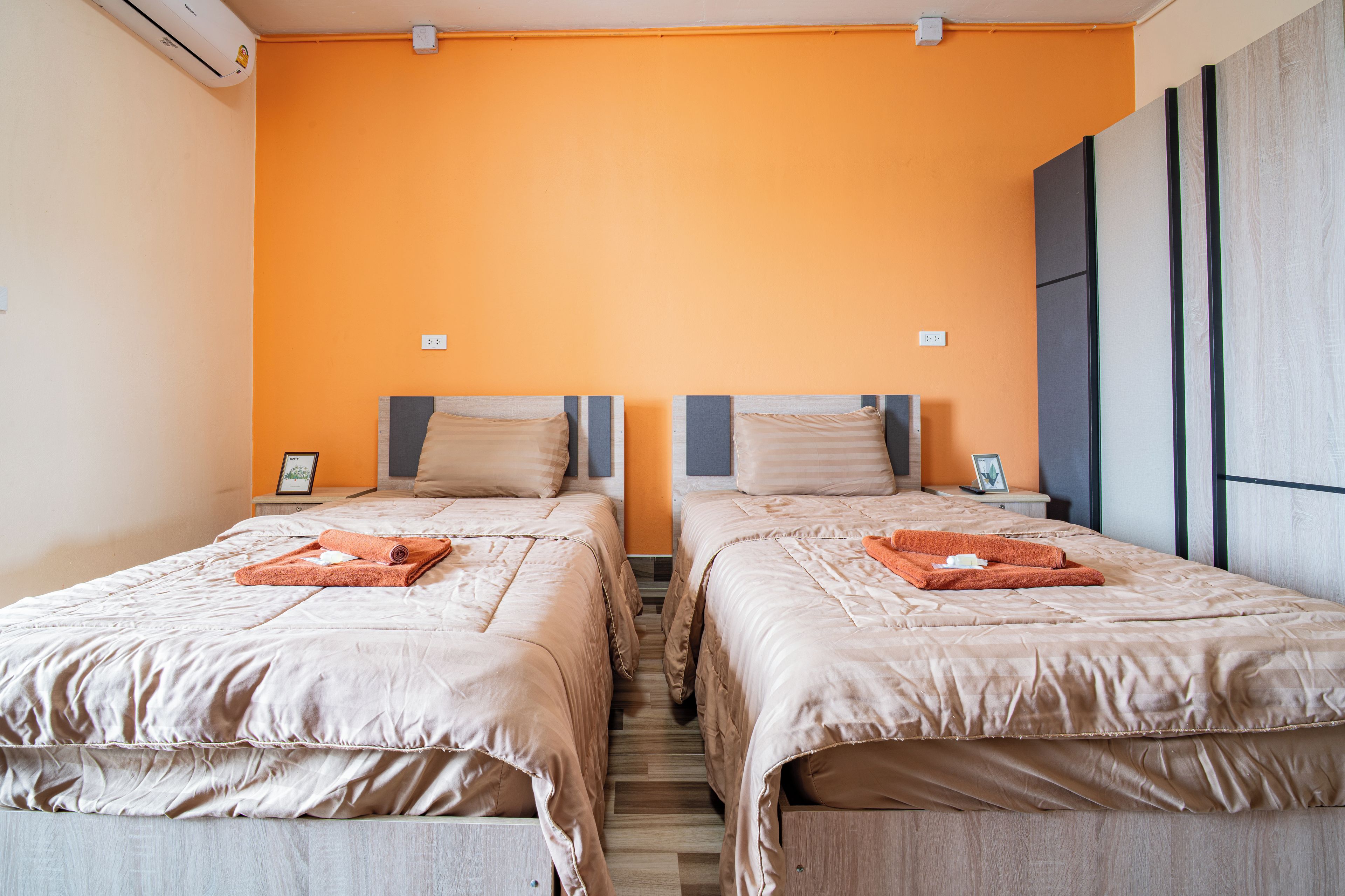 A hotel room with two beds, each with a neatly folded towel and a pillow.