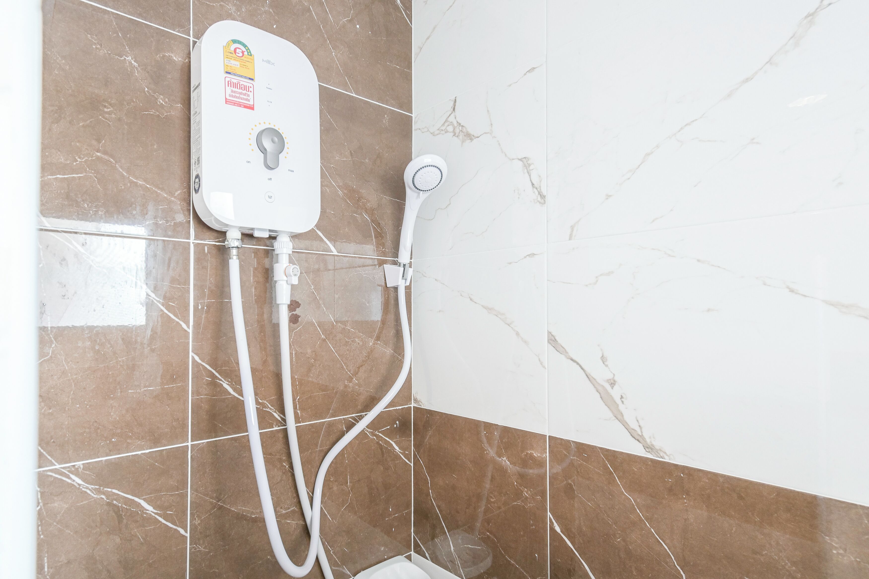Un bagno con doccia, pannello di controllo e soffione a mano.