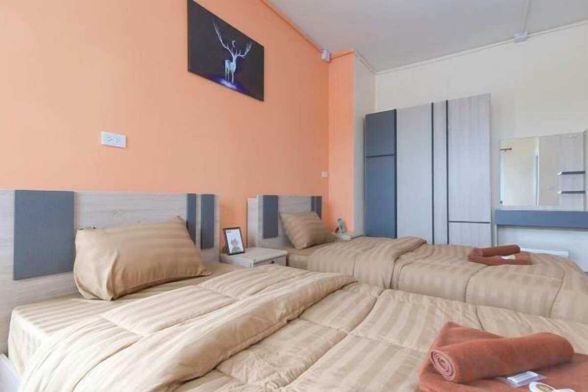 A hotel room with two beds, a large mirror, and a wall-mounted picture.