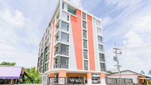 A multi-story building with balconies and a parking area. - The Wish Hotel (Chachoengsao)