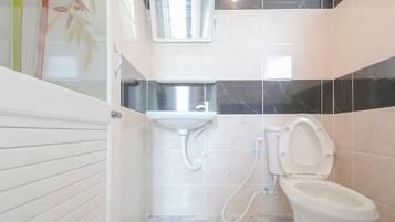 Un baño con inodoro, lavamanos y ducha.