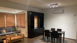 A modern living room with a sofa, coffee table, and dining area. - Less than five minutes from the beach, restaurants, supermarkets, bakery's (Paralimni)