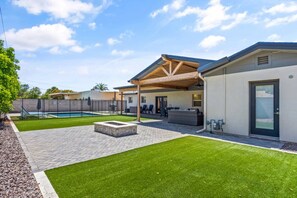 A residential property with a swimming pool, patio area, and covered outdoor seating.