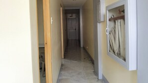 A hallway with a tiled floor, a wooden door frame, and a wall-mounted coat rack. - Rivoli Hotel (San Pablo)