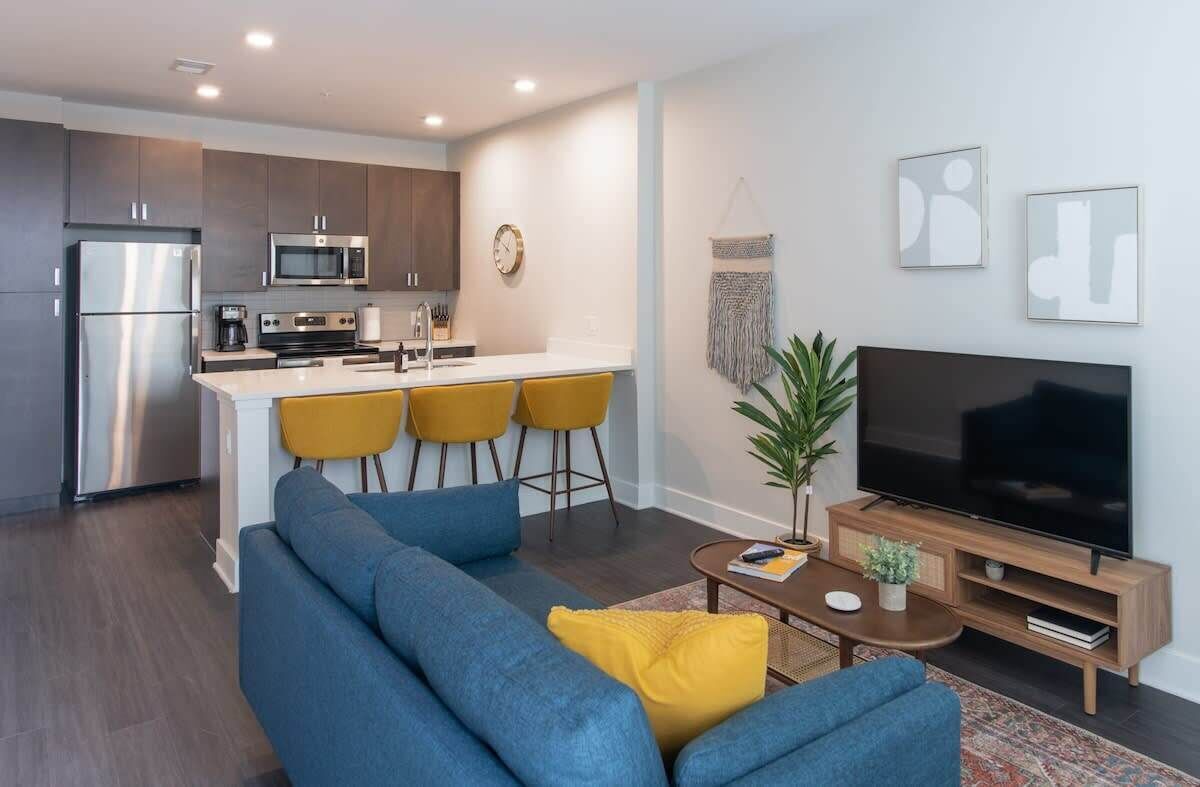 A modern apartment with a kitchen, dining area, and living room.