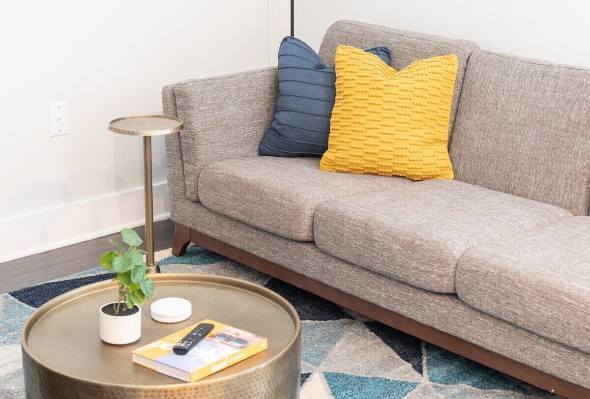 A living room with a grey sofa, a small round coffee table, and a floor lamp.