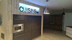 A modern kitchen with a built-in microwave, wooden cabinets, and a pendant light.