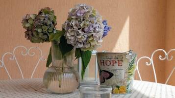 A table with two vases of flowers and a tin labeled "HOPE".