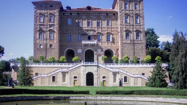 A large, historic building with multiple arches and a central staircase.