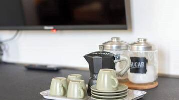 Un ensemble pour préparer le café comprenant une cafetière, un récipient à sucre et quatre tasses, le tout disposé sur un plateau.