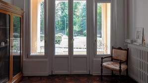 A room with a large window, a radiator, and a chair.