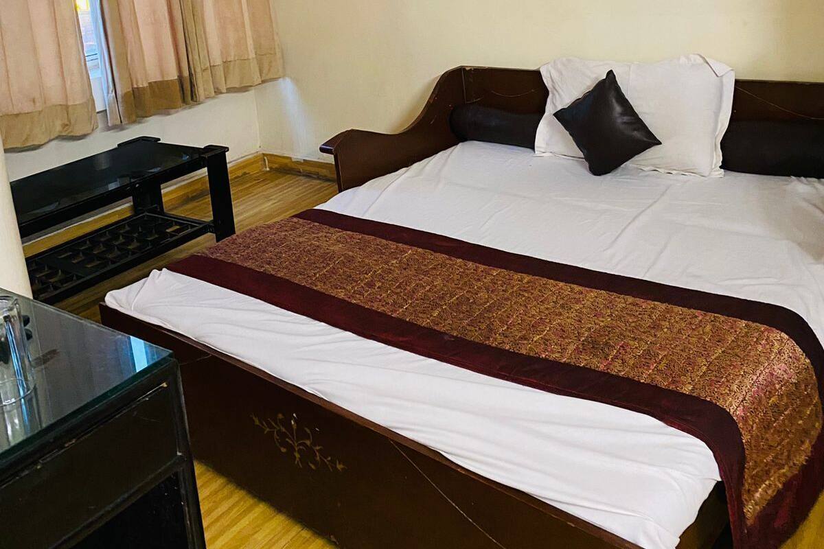 Habitación de hotel con una cama grande, un escritorio y una ventana con cortinas.