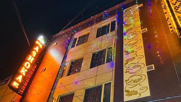 A building with a sign for "Hotel Okura" and a large illuminated sign for "IYA". - Hotel Ashoka International (New Delhi)