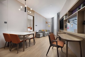 Un interior modern amb zona de menjador, sofà i petita cuina.