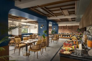 Un restaurant avec de hauts plafonds, des poutres apparentes et un espace buffet proposant une variété de plats et de boissons.